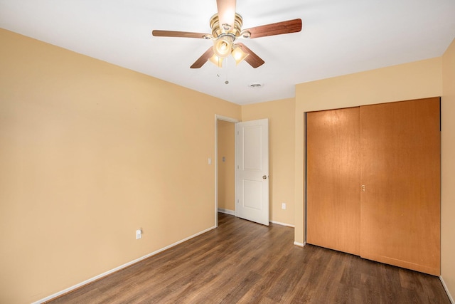 unfurnished bedroom with a closet, a ceiling fan, baseboards, and wood finished floors