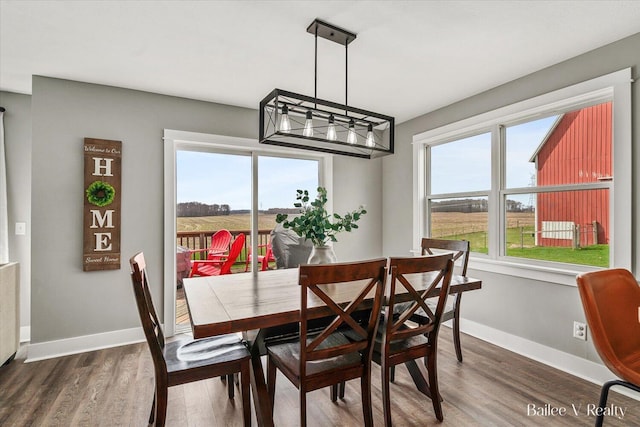 dining area with baseboards, wood finished floors, and a chandelier