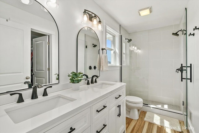 full bath featuring toilet, visible vents, a shower stall, and a sink