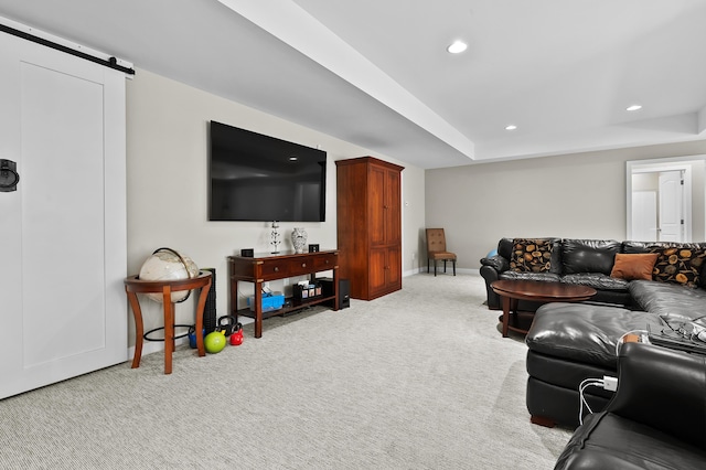 carpeted living room with recessed lighting, a barn door, baseboards, and a tray ceiling