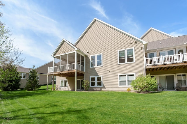 rear view of house with a lawn and a sunroom