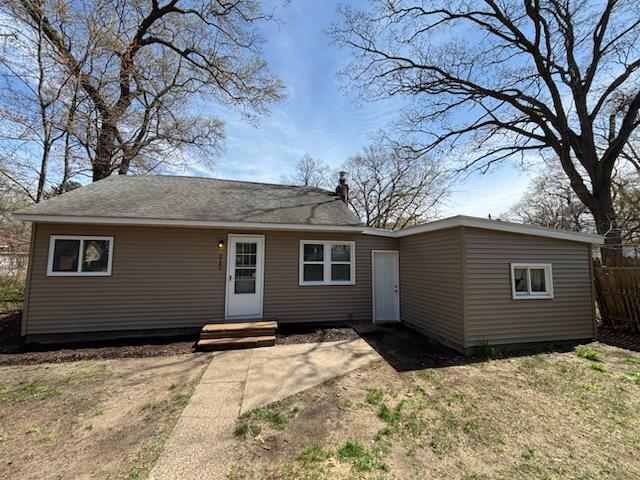 back of house with fence and a chimney