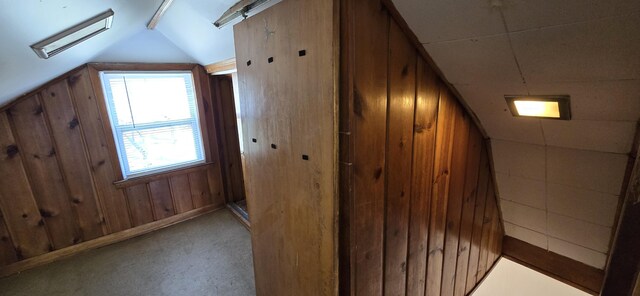 additional living space with wood walls and lofted ceiling
