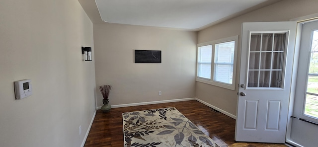 doorway to outside featuring baseboards, visible vents, a wealth of natural light, and wood finished floors