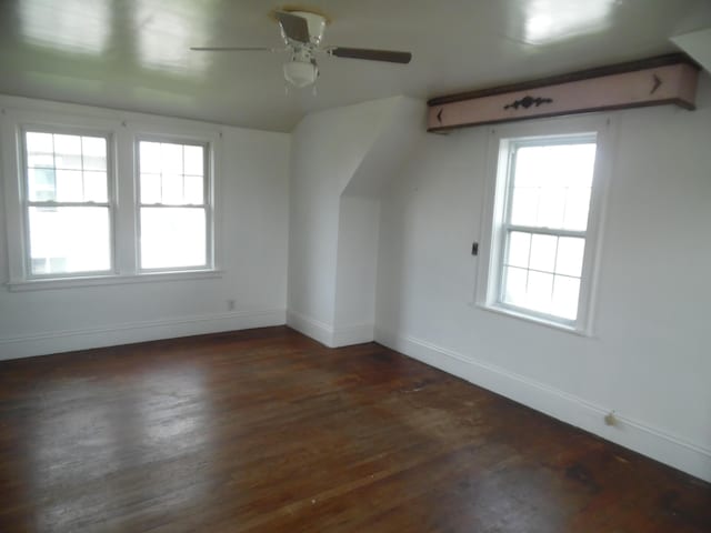 additional living space featuring a ceiling fan, baseboards, and wood finished floors