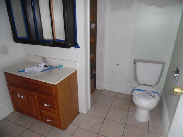 half bath with toilet, tile patterned flooring, and vanity