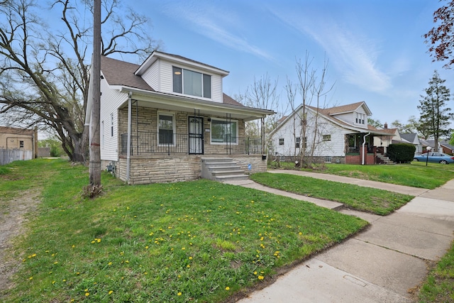 bungalow with a front lawn, fence, covered porch, and stone siding
