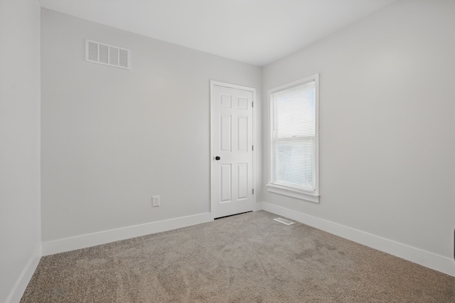 spare room with visible vents, carpet flooring, and baseboards