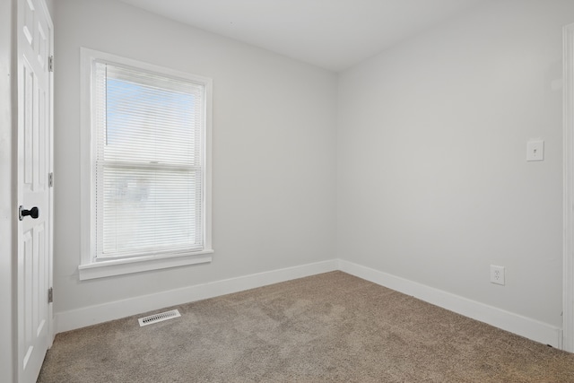 spare room featuring baseboards, visible vents, a healthy amount of sunlight, and carpet