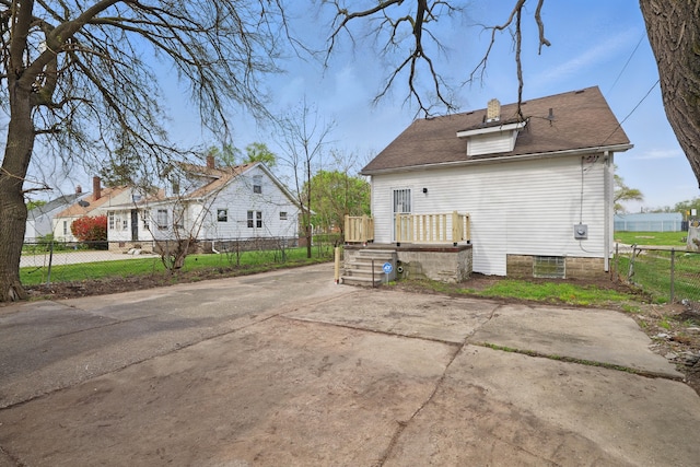 back of property featuring fence and a chimney