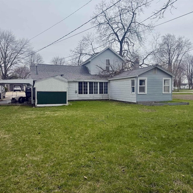 back of house featuring a lawn, a chimney, and a shingled roof