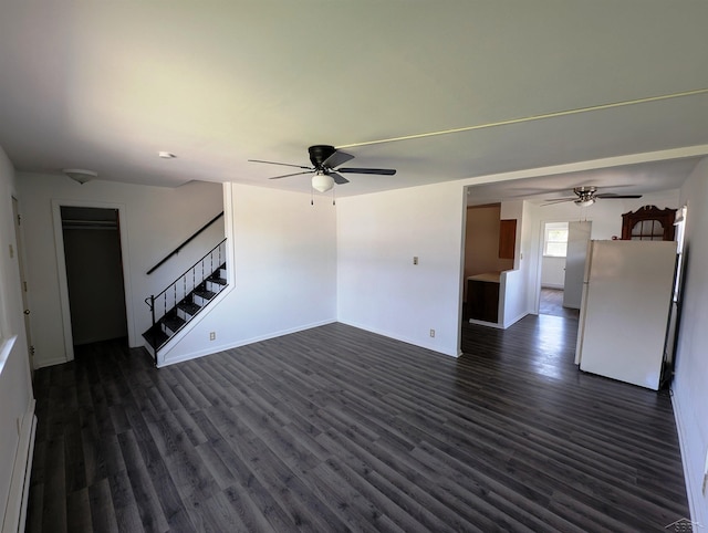 unfurnished living room featuring dark wood-style flooring, a ceiling fan, baseboards, and stairway