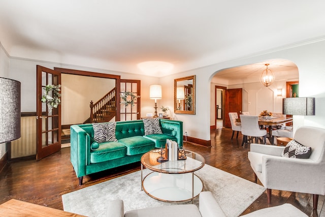 16924 Muirland St, Detroit, MI 48221 - living room featuring an inviting chandelier, stairs, wood finished floors, baseboards, and arched walkways