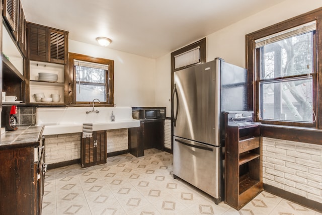 16924 Muirland St, Detroit, MI 48221 - kitchen with freestanding refrigerator, open shelves, dark brown cabinetry, tile counters, and light tile patterned floors