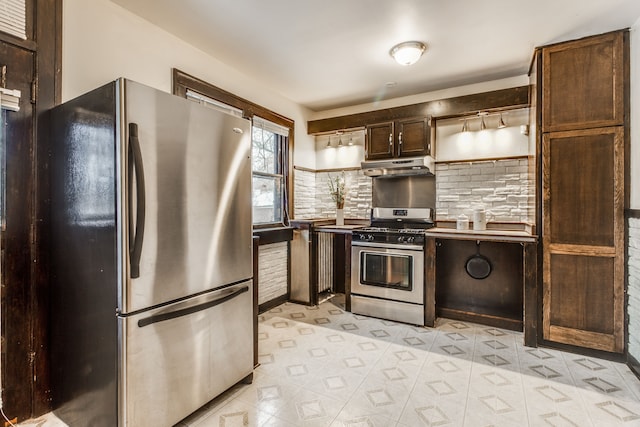 16924 Muirland St, Detroit, MI 48221 - kitchen with dark brown cabinetry, light floors, under cabinet range hood, tasteful backsplash, and appliances with stainless steel finishes