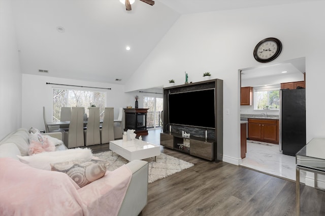 living area with visible vents, wood finished floors, ceiling fan, high vaulted ceiling, and recessed lighting