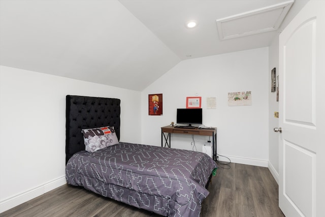 bedroom featuring vaulted ceiling, baseboards, attic access, and wood finished floors