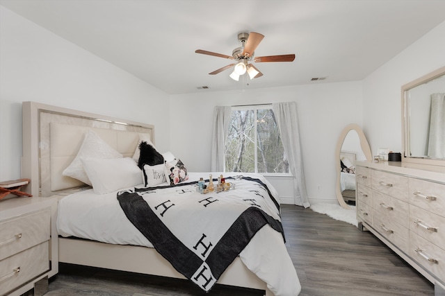 bedroom with ceiling fan, visible vents, baseboards, and dark wood-type flooring