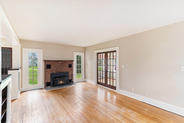 unfurnished living room featuring baseboards, french doors, and light wood-style flooring
