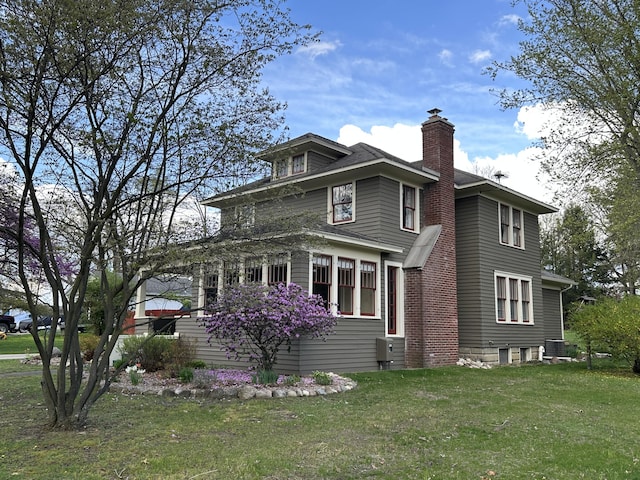 exterior space featuring central AC unit, a yard, and a chimney