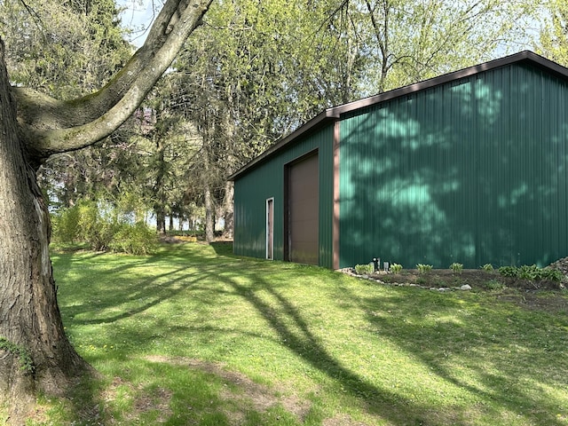 view of yard with a garage and an outbuilding