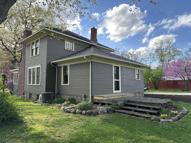 back of house with a lawn, central AC, a chimney, and a wooden deck