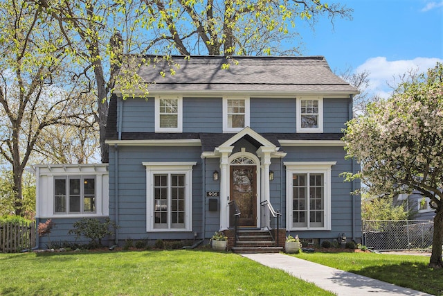 906 Granger Ave, Ann Arbor, MI 48104 - view of front facade with a front lawn, roof with shingles, fence, and a chimney