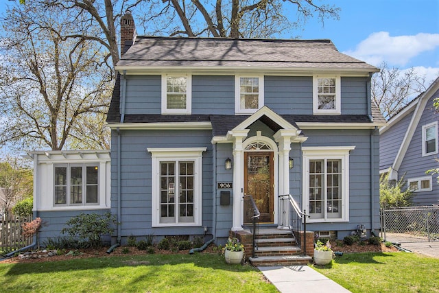 906 Granger Ave, Ann Arbor, MI 48104 - view of front of property with fence, a chimney, a shingled roof, and a front lawn