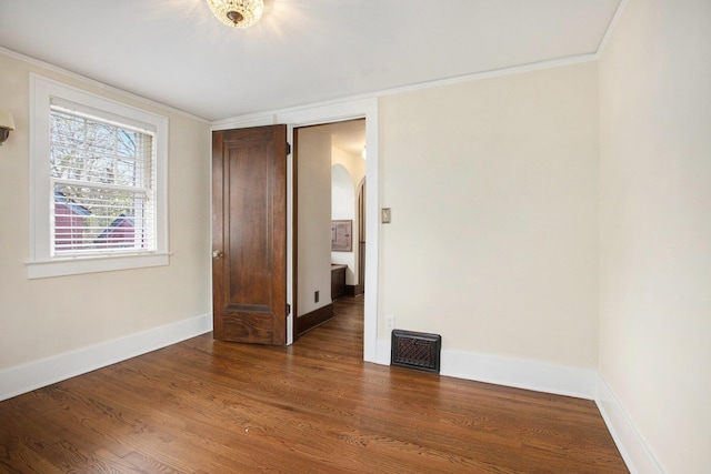 906 Granger Ave, Ann Arbor, MI 48104 - unfurnished room featuring visible vents, arched walkways, wood finished floors, baseboards, and ornamental molding