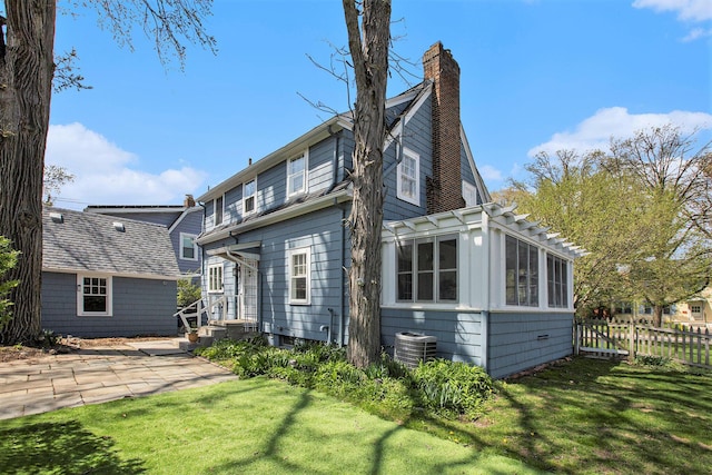 906 Granger Ave, Ann Arbor, MI 48104 - back of house with fence, central air condition unit, a chimney, and a lawn