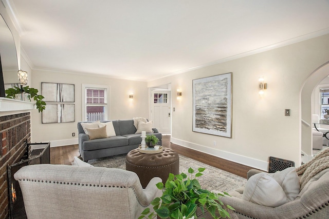 906 Granger Ave, Ann Arbor, MI 48104 - living room with crown molding, a brick fireplace, baseboards, dark wood-type flooring, and arched walkways