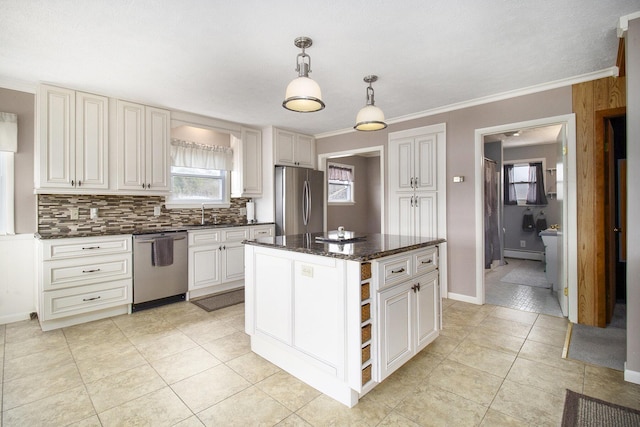 kitchen with stainless steel appliances, tasteful backsplash, a baseboard radiator, a sink, and light tile patterned floors