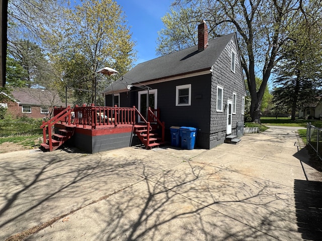 2361 Montroyal Ave, Waterford, MI 48328 - back of property with a deck, a chimney, a shingled roof, and a patio area