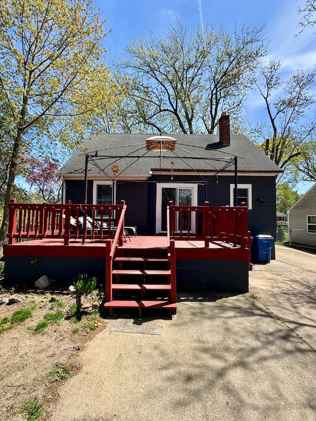 2361 Montroyal Ave, Waterford, MI 48328 - rear view of property featuring a deck, a shingled roof, and a chimney