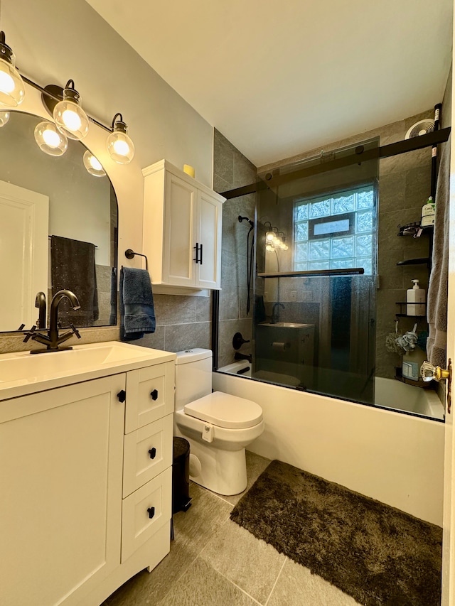 2361 Montroyal Ave, Waterford, MI 48328 - full bath featuring tile walls, tile patterned flooring, vanity, toilet, and shower / bath combination with glass door