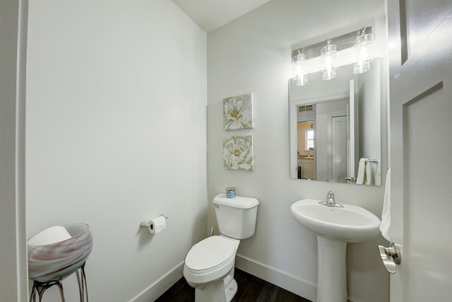 3088 Painted Dr, Howell, MI 48843 - half bathroom featuring wood finished floors, baseboards, toilet, and a sink