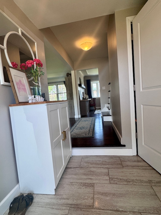hall featuring baseboards and wood finished floors