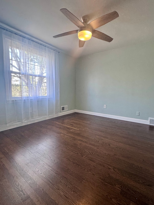 unfurnished room featuring a ceiling fan, baseboards, dark wood finished floors, and visible vents