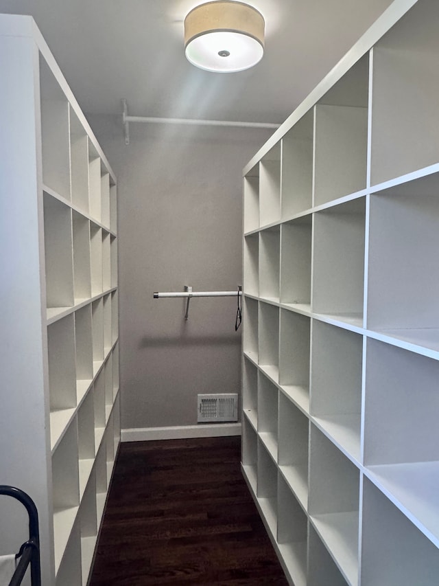 walk in closet with dark wood-style flooring and visible vents