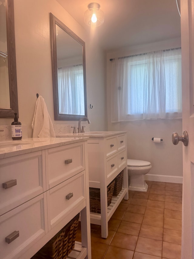 bathroom featuring tile patterned floors, plenty of natural light, vanity, and toilet