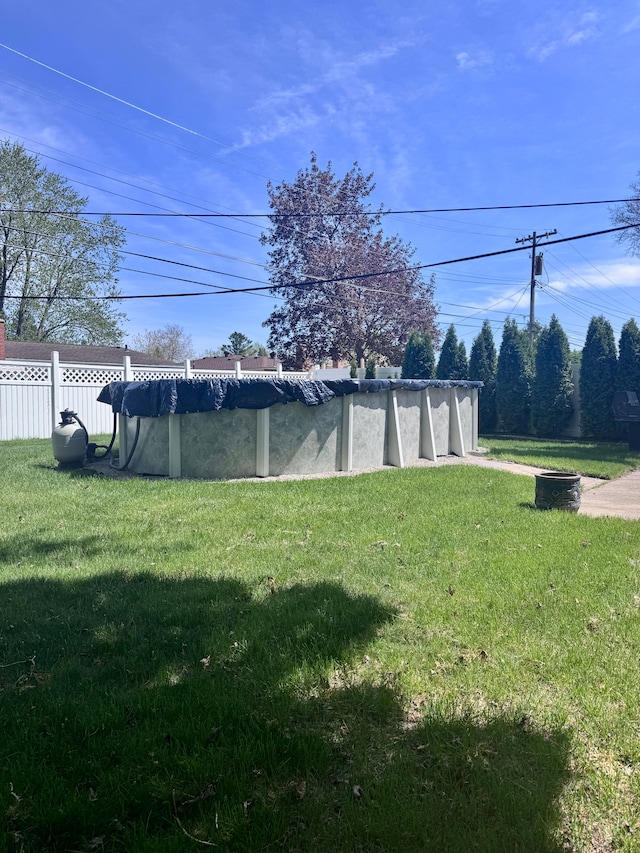 view of yard featuring fence and a covered pool
