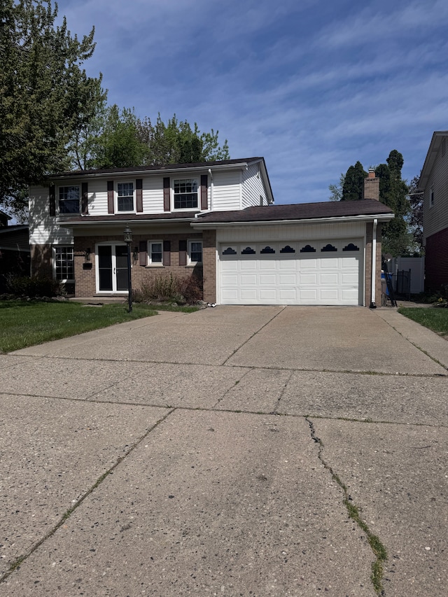 traditional-style home featuring a garage, driveway, and brick siding