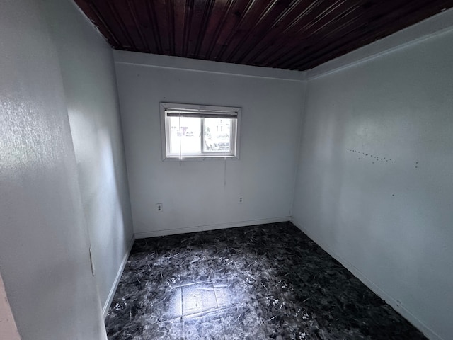 unfurnished room featuring baseboards and wooden ceiling