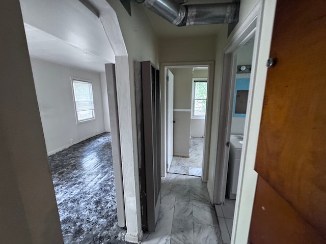 hall featuring a heating unit and marble finish floor