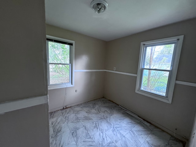 spare room with marble finish floor