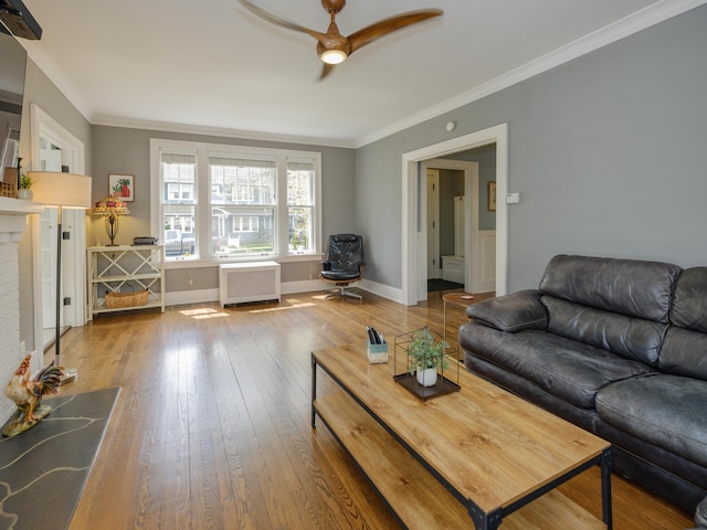 living room with wood-type flooring, ceiling fan, crown molding, and radiator