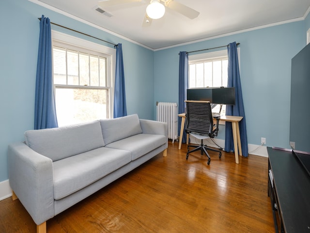 office area with crown molding, visible vents, radiator heating unit, and wood finished floors
