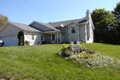 tri-level home with a chimney, a garage, and a front yard