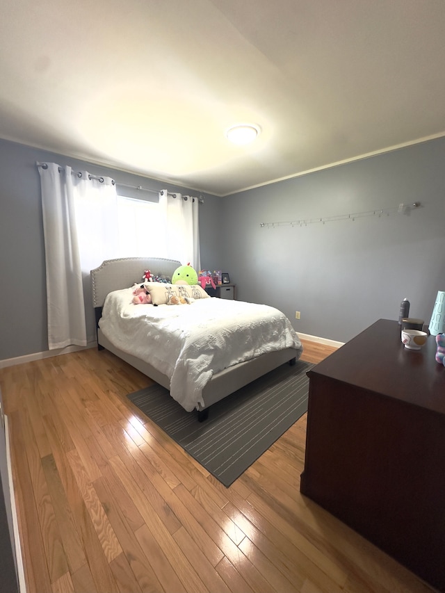 bedroom with baseboards and wood finished floors