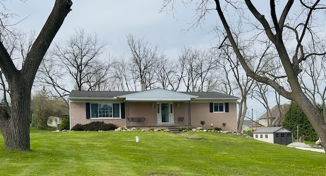 view of front of property with brick siding, a front lawn, and a chimney